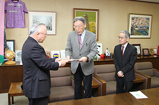杉本市長に提言書を提出する坂本委員長（中央）と山本副委員長（右）の画像