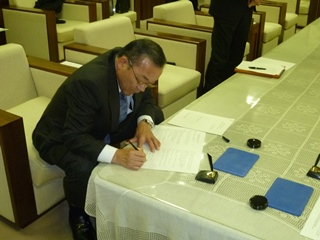 協定書にサインする本巣市の藤原市長の画像
