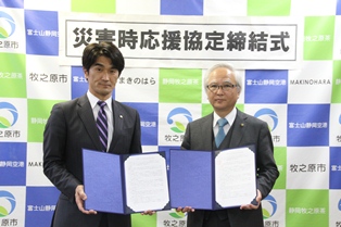 協定書を取り交わした高橋部長（写真左）と西原市長の画像