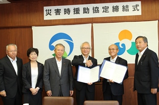 握手を交わす桜井市長（右から2番目）と西原市長（右から3番目）の画像