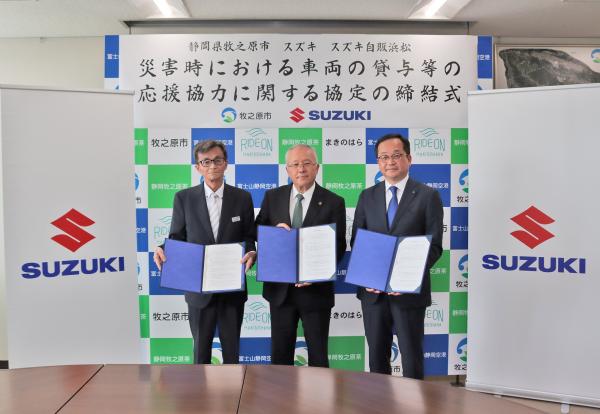 牧之原市、スズキ㈱、㈱スズキ自販浜松の三者で協定書を手に持った写真